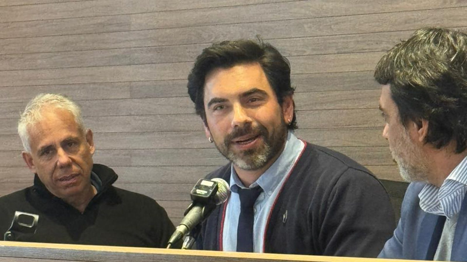 Bruno falando ao microfone em uma mesa de debate