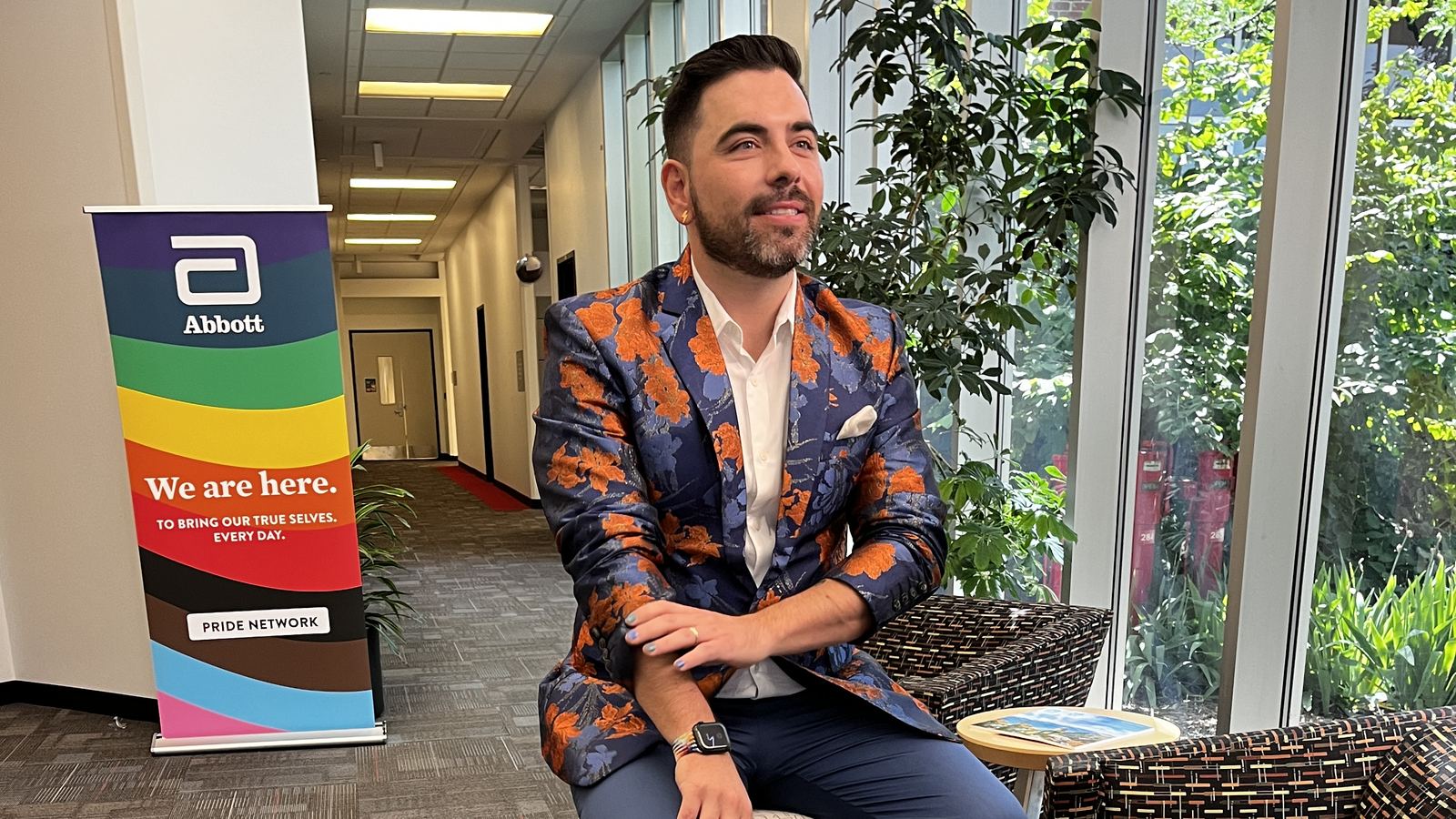 Bruno em gravação ao lado do banner do PRIDE Network da Abbott